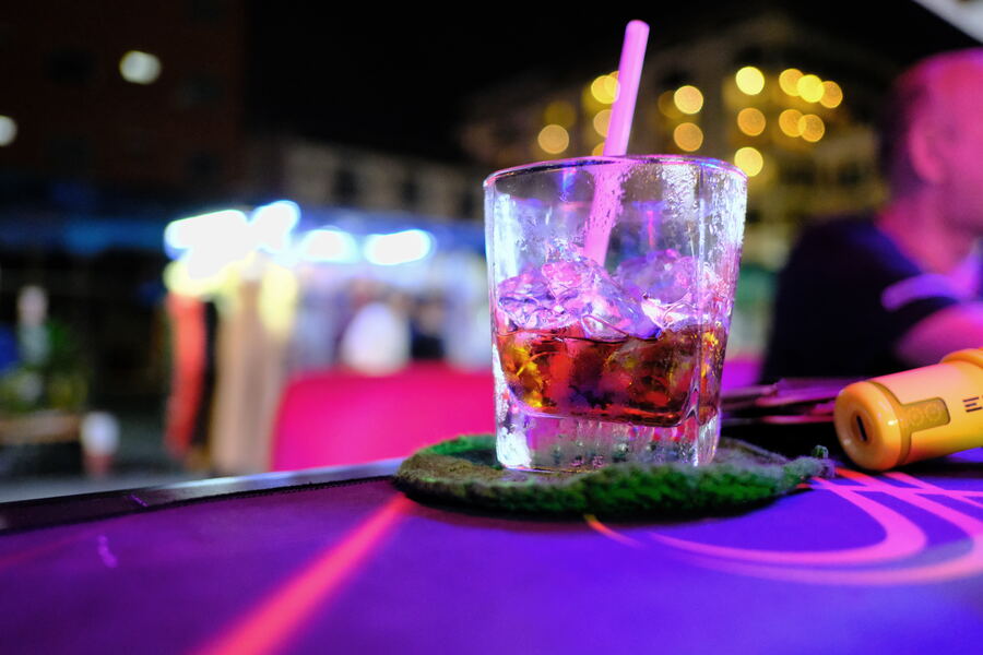 A cocktail on a bar under neon light