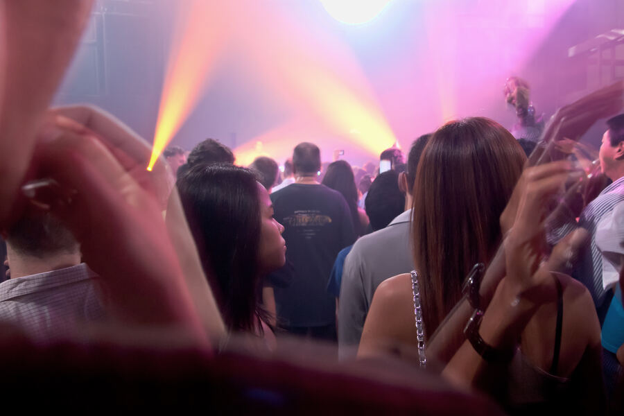 A crowd under lights on a club floor