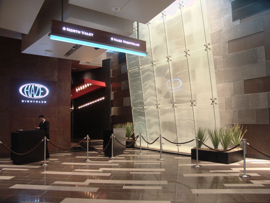 A nightclub entrance with stanchions and a host stand